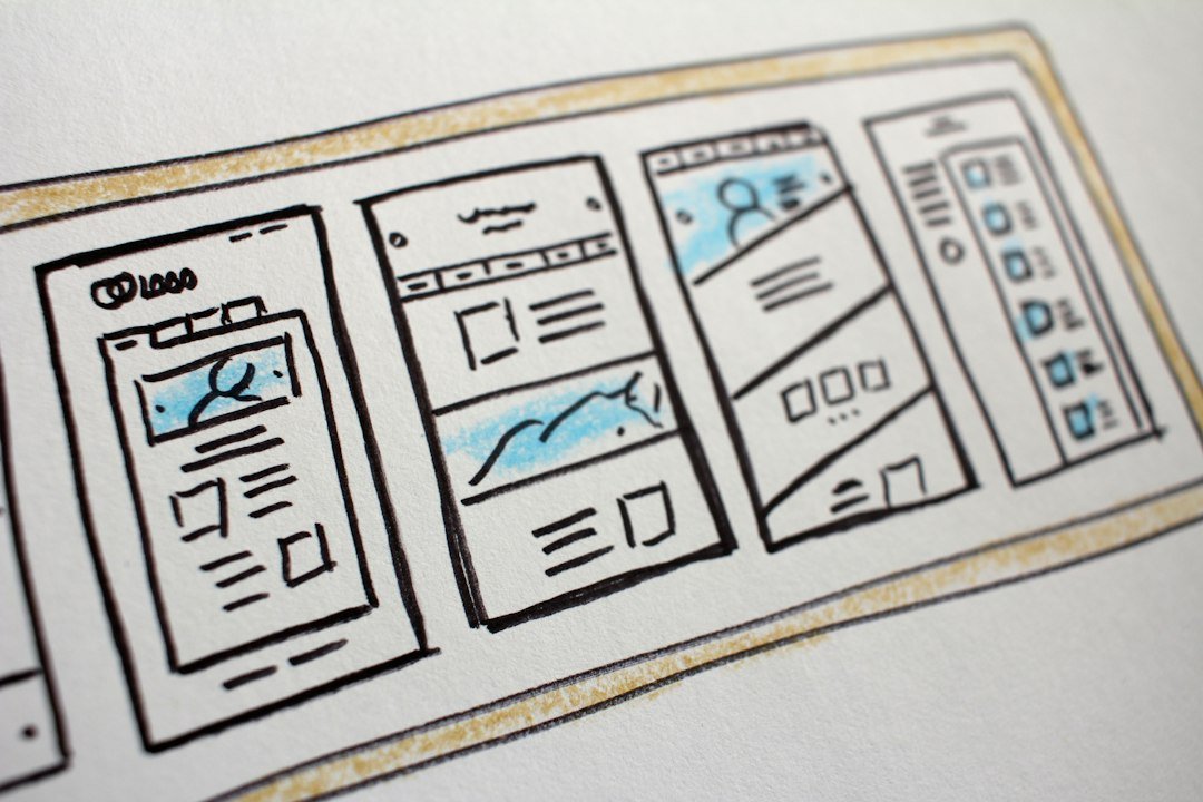 Photograph of paper website wireframes with blue annotations